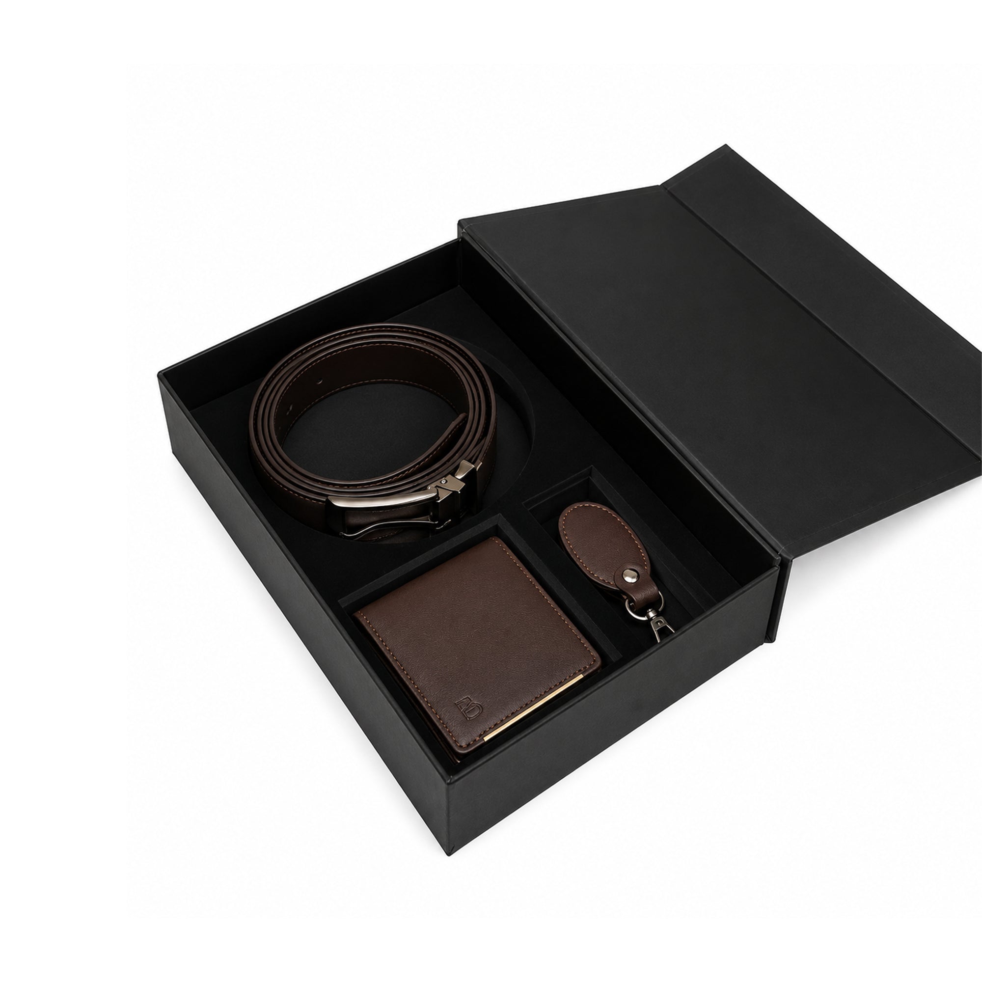 A men's accessory gift set in a black presentation box, featuring a dark brown leather belt with a silver buckle, a matching brown leather wallet, and a small leather keychain.